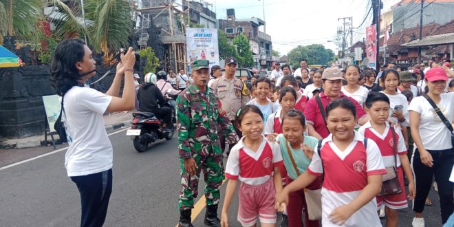 Babinsa Pemecutan Atensi Gerak Jalan Santai Dalam Rangka HUT Stt Eka Dharma Suwitra Ke 71